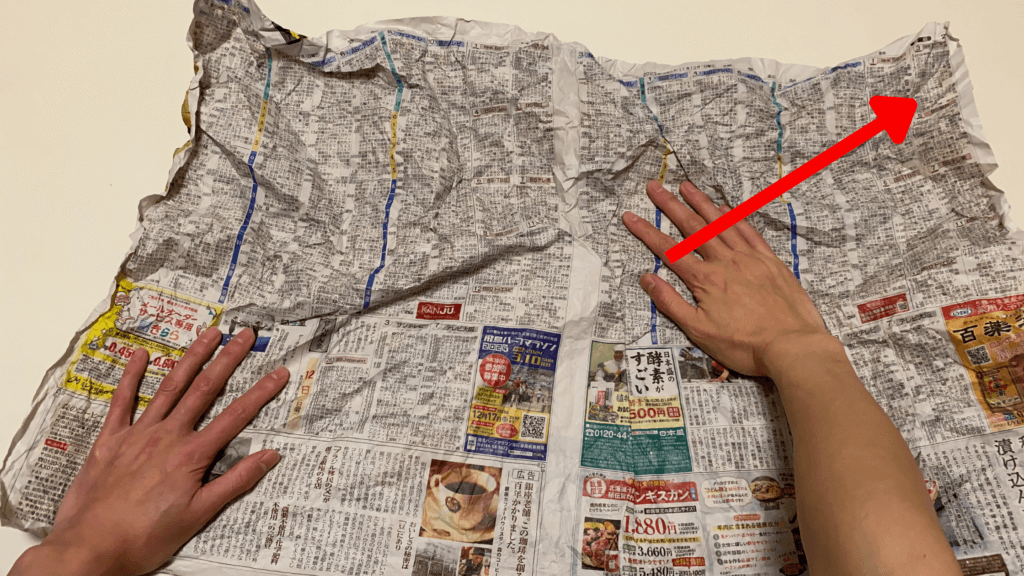 新聞紙を斜めに向かって広げます。